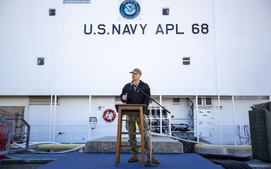 Rear Adm. William Greene addresses the crowd during a ribbon-cutting ceremony for the new housing barge, Auxiliary Personnel Lighter 68, at the Norfolk Naval Shipyard in Portsmouth, Va., on Nov. 21, 2022.
