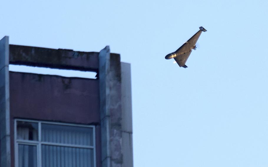 A drone flies past a building.