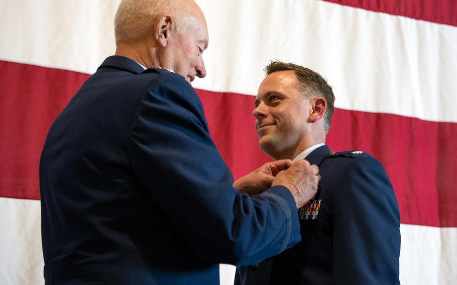Retired Lt. Gen. Harry Wyatt III presents Lt. Col. Michael Coloney with the Distinguished Flying Cross at the Tulsa Air National Guard Base in Oklahoma on Dec. 5, 2021. Coloney received the medal for his heroism during a mission in Afghanistan in 2018. 
