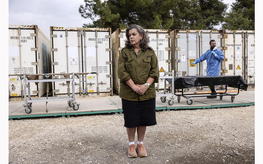 A volunteer with Israel's military rabbinate who helped prepare remains of women killed by fighters from Gaza on Oct. 7 stands near refrigerated containers that hold bodies, body parts and ashes at a makeshift morgue for soldiers on the Shura military base near Ramla on Oct. 29, 2023.