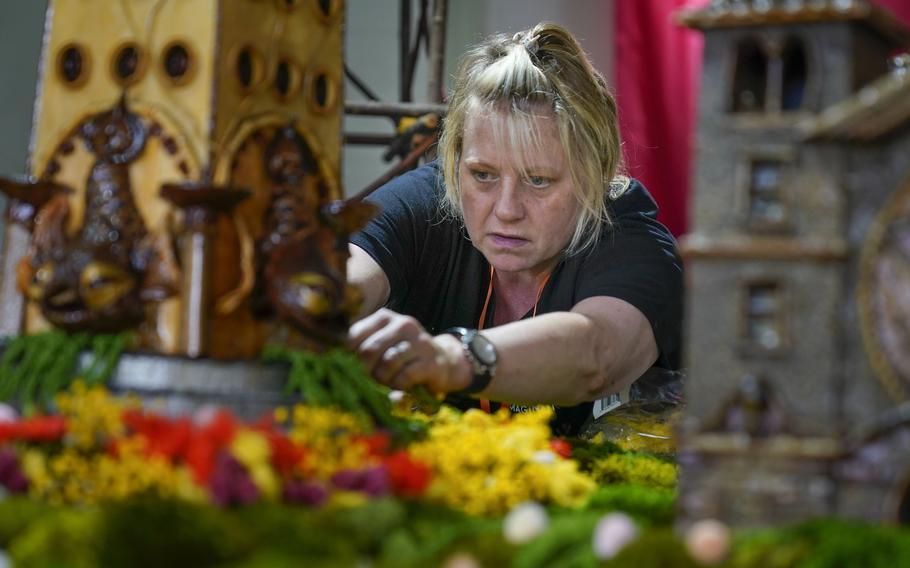 Stephanie Winters fills in the landscaping around a Coney Island themed display as part of the preparation for the annual Holiday Train Show at the New York Botanical Garden in New York, Thursday, Nov. 11, 2021. The show, which opens to the public next weekend, features model trains running through and around New York landmarks, recreated in miniature with natural materials. 