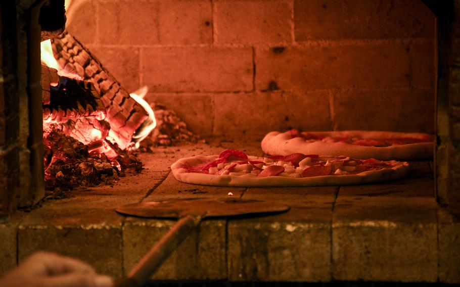 Pizzas bake in a wood-fired oven at JaMaMaSi, a food truck across from Kleber Kaserne in Kaiserslautern, Germany.   