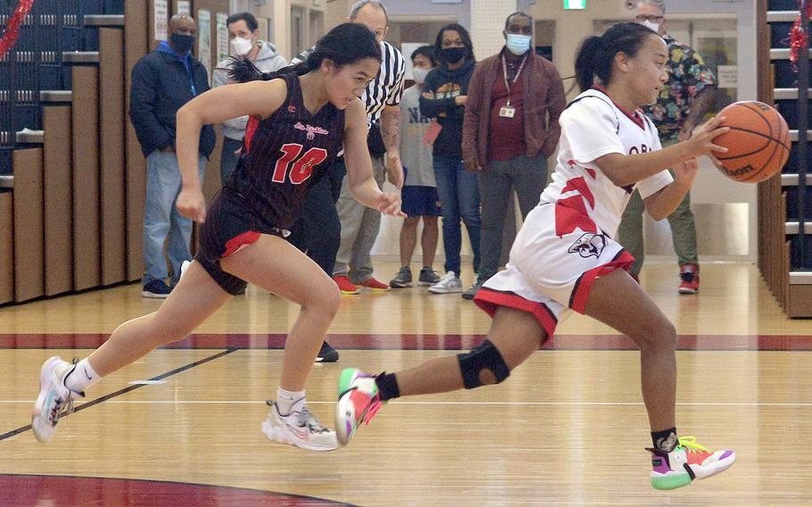 E.J. King's Miu Beste dribbles free of Nile C. Kinnick's Mikaila Joi Miranda during Friday's DODEA-Japan girls basketball game. The Red Devils won 60-34.