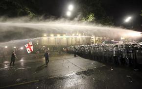 Riot police use a water cannon during an opposition protest against "the Russian law" near the Parliament building in Tbilisi, Georgia, on Wednesday, May 1, 2024. Clashes erupted between police and opposition demonstrators protesting a new bill intended to track foreign influence that the opposition denounced as Russia-inspired. (AP Photo/Zurab Tsertsvadze)