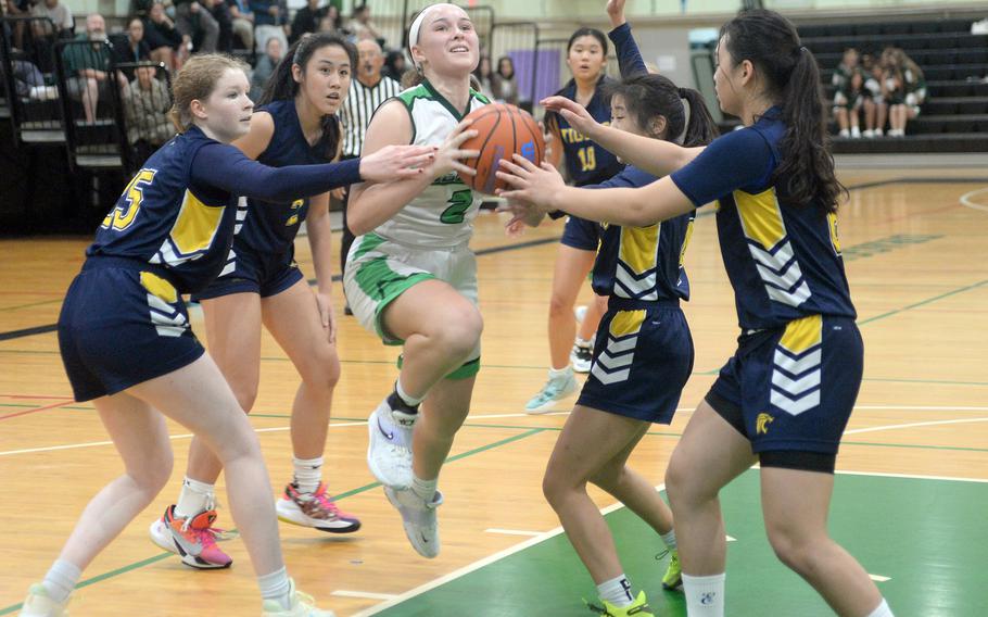 Kubasaki's Jacquline Mitchell threads her way between Taipei American defenders during Friday's inter-district girls basketball game. The Tigers won 58-31.