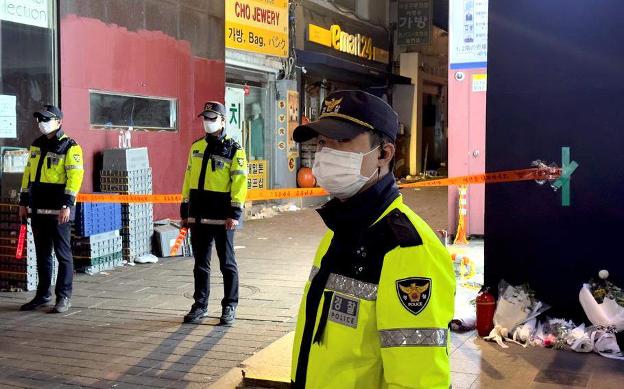 South Korean police guard the entrance to an alleyway where some of the 159 victims were killed after a crowd of people were crushed during Halloween festivities in Itaewon, South Korea, Oct. 29, 2022.