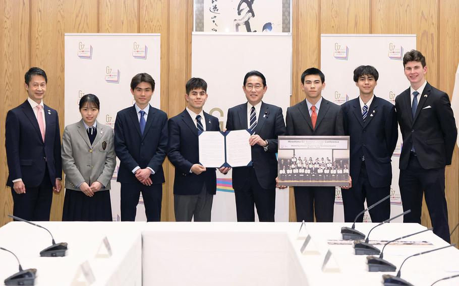 Japanese Prime Minister Fumio Kishida poses with students, including military teen Aiden O’Reilly, far right, who took part in the G-7 Hiroshima Summit Junior Conference, at his office in Tokyo, April 5, 2023.