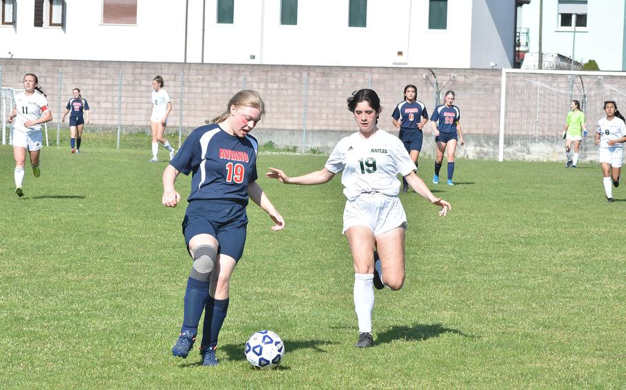 Aviano's Audrey Belden-Cruz beats Naples' Amber Ozturkoglu to the ball Saturday, April 16, 2022, during the Wildcats' 5-3 victory over the Saints in Aviano, Italy.
