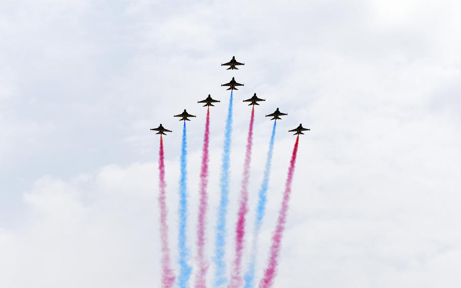 South Korean Black Eagles soar in formation, tailed by red and blue contrast. 