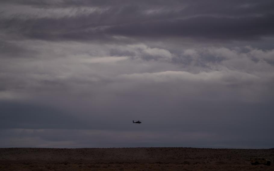 A helicopter flies over the horizon at the National Training Center. 