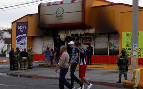 Members of the Mexican Army, firefighters and forensic experts work at the site where unknown persons burnt down shops in Ciudad Juarez, state of Chihuahua, Mexico, on Aug. 11, 2022. (Herika Martinez/AFP via Getty Images/TNS)