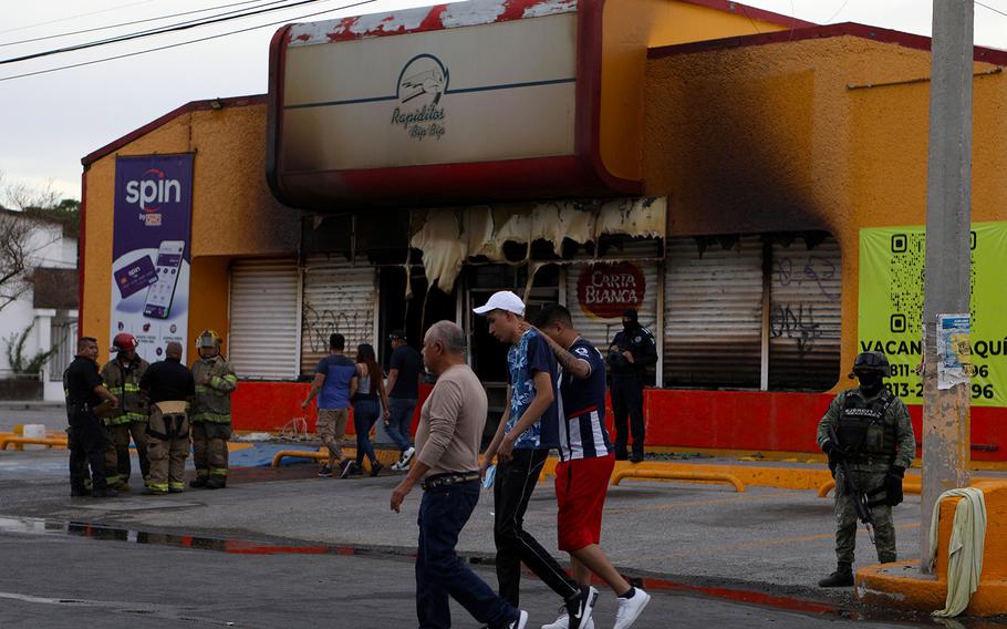 Members of the Mexican Army, firefighters and forensic experts work at the site where unknown persons burnt down shops in Ciudad Juarez, state of Chihuahua, Mexico, on Aug. 11, 2022. 