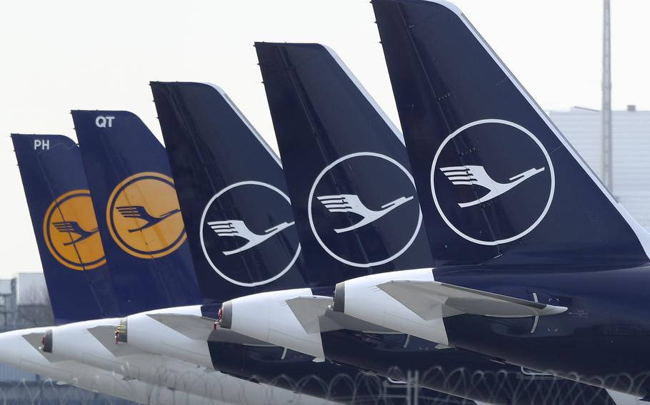 German Lufthansa planes sit parked in a line at the airport in Munich, Germany, Thursday, March 26, 2020. 