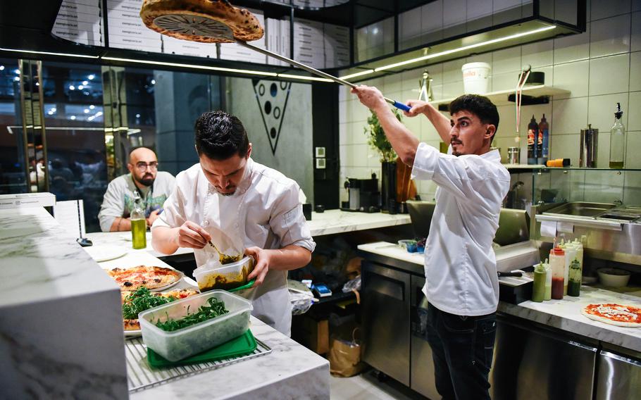 Food is prepared n the pizzeria kitchen.