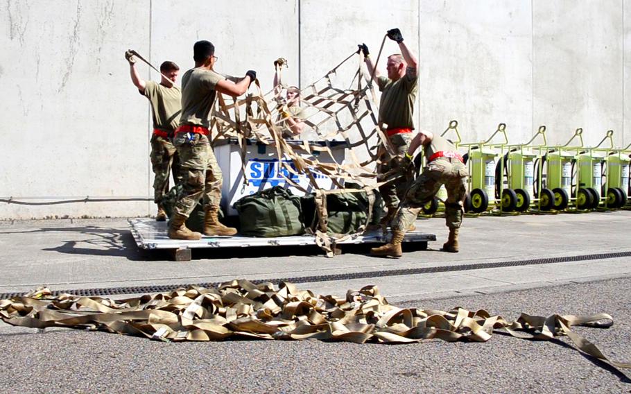 The Raven's Fury team from Spangdahlem Air Base holds webbing over a pallet during the endurance event at the 721st Aerial Port Squadron's Multi-Capable Airmen Rodeo at Ramstein Air Base on July 23, 2021. The team, part of the 726th Air Mobility Squadron, lost time in the final test in the endurance event after they put the webbing on wrong. 