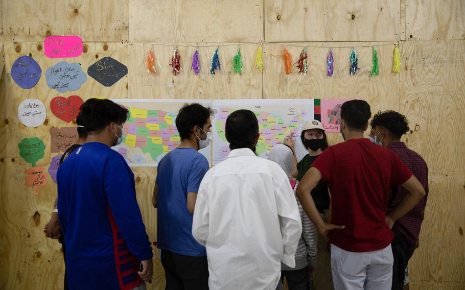 A Department of Homeland Security volunteer points out different U.S states on a map during the opening of a new education center at Aman Omid Village on Holloman Air Force Base, N.M., Oct. 19, 2021. 