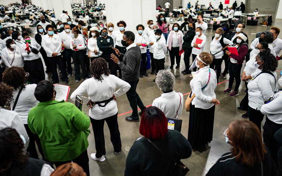 Poll workers gather for a meeting before counting ballots during the 2020 general election at the TFC Center in Detroit on Nov. 3, 2020. 