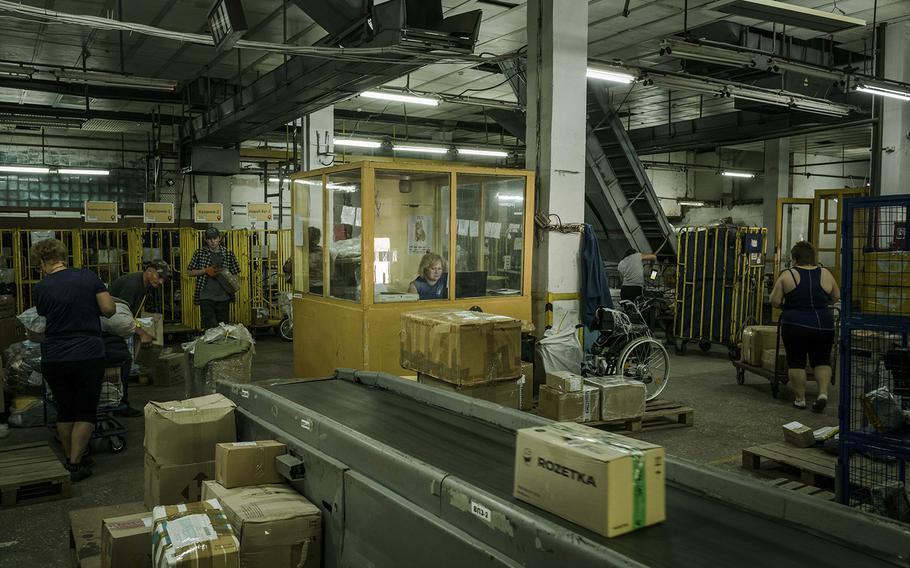 Postal workers sorting packages at a facility in Mykolaiv on July 15. Despite the war, Ukraine’s postal service is still delivering mail. 