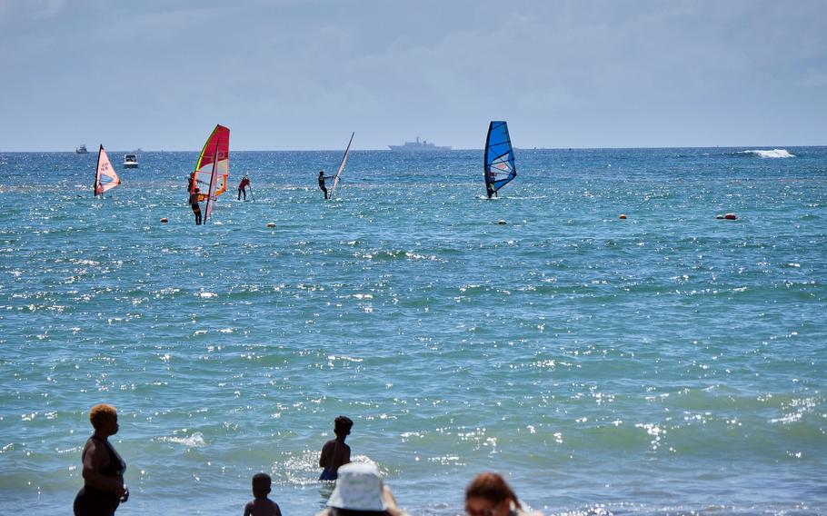 Beachgoers cool off in the water at Zushi Beach in Kanagawa prefecture, Japan, Tuesday, Aug. 3, 2021.