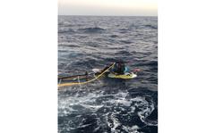 In a photo posted to Twitter by the U.S. Coast Guard, a Cuban citizen sits stranded on a windsurf board about 15 miles off the Florida Keys on Wednesday, March 23, 2022. 