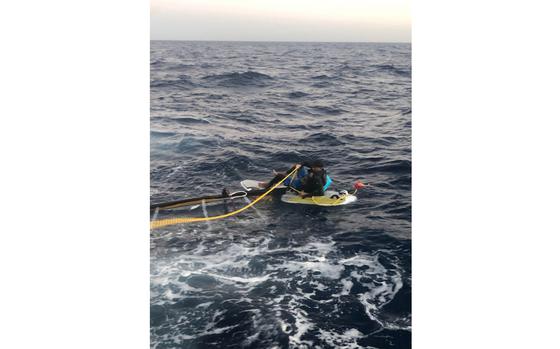 In a photo posted to Twitter by the U.S. Coast Guard, a Cuban citizen sits stranded on a windsurf board about 15 miles off the Florida Keys on Wednesday, March 23, 2022. 