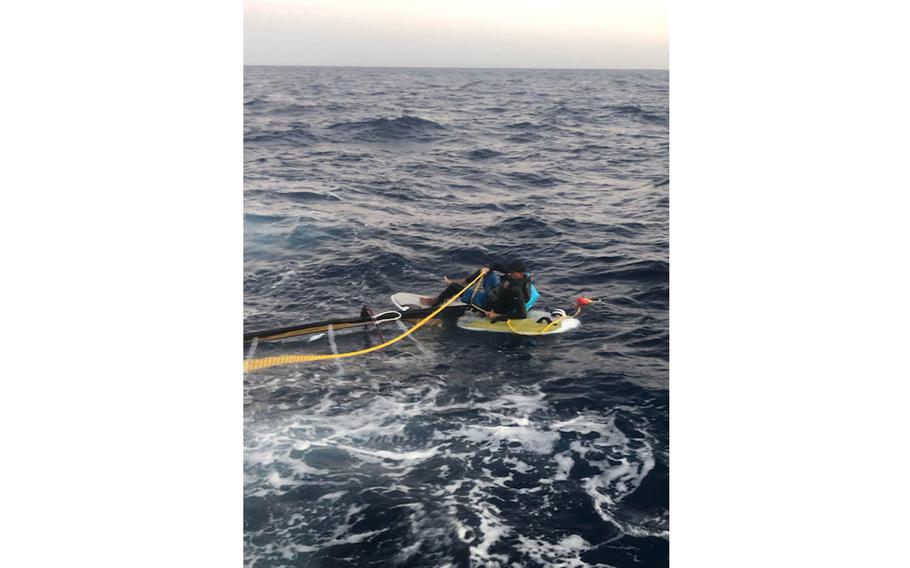 In a photo posted to Twitter by the U.S. Coast Guard, Elián López Cabrera sits stranded on a windsurf board about 15 miles off the Florida Keys on Wednesday, March 23, 2022. 