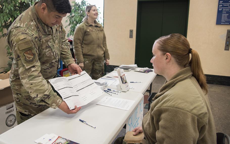 Master Sgt. Abraham Vallejo, 374th Airlift Wing, explains to Airman First Class Carlie Daggett, 374th Logistics Readiness Squadron, how to register as a bone marrow donor at the exchange on Yokota Air Base, Japan, on March 28, 2023. 