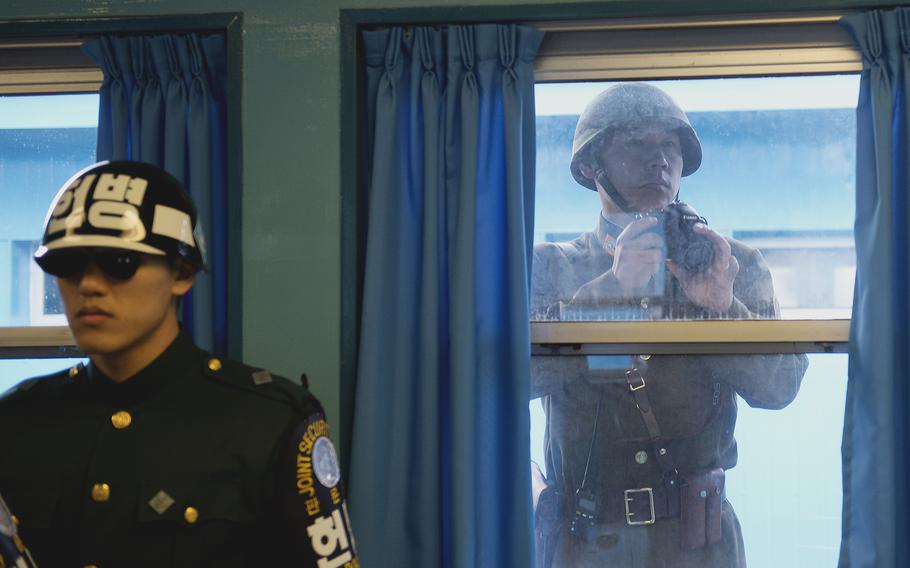 A North Korean soldier takes photos through the window while U.S. Army Gen. Martin E. Dempsey, chairman of the Joint Chiefs of Staff, is briefed at the Demilitarized Zone in South Korea, Nov. 11, 2012. 