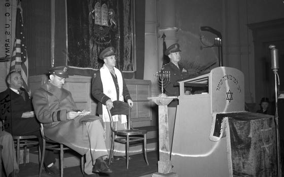 Wiesbaden, Germany, Dec. 22, 1946: Rededication ceremony of the Jewish Synagogue Center of Wiesbaden, December 22, 1946. The Orthodox Synagogue in Wiesbaden was desecrated and defiled November 10, 1938 - also known as Kristalnacht - the night of November 9th onto 10th when Nazis in Germany, annexed Austria and in the areas of the Sudetenland in then Czechoslovakia torched synagogues, vandalized Jewish homes, schools and businesses and killed hundreds of Jews. The restoration of the building was partly made possible with the assistance of the U.S. occupational forces stationed at the Headquarters Command, United States Air Forces in Europe, Wiesbaden Air Base. Maj. Gen. Idwal H. Edwards, Commanding General, USAFE (standing at the lectern, right), Chaplain Capt. William Z. Dalin Hq. Command, USAFE (standing, left); Brig. Gen. J. H. McCormick, Assistant Chief of Staff, A-1, Hq. USAFE (seated, right); and Rabbi Philip S. Bernstein, advisor to Theater Command on Jewish Affairs. Rabbi Bernstein would become known for his work resettling hundreds of thousands of displaced European Jews after World War II. Chaplain Dalin served as the only Jewish chaplain of the U.S. Air Corps at the time and served as an aide to Rabbi Bernstein, also assisting Jewish displaced persons.

META TAGS: Judaism; Jewish faith; religion; synagogue; Jews; religious ceremony; United States Air Forces in Europe; reconstruction; rebuilding;