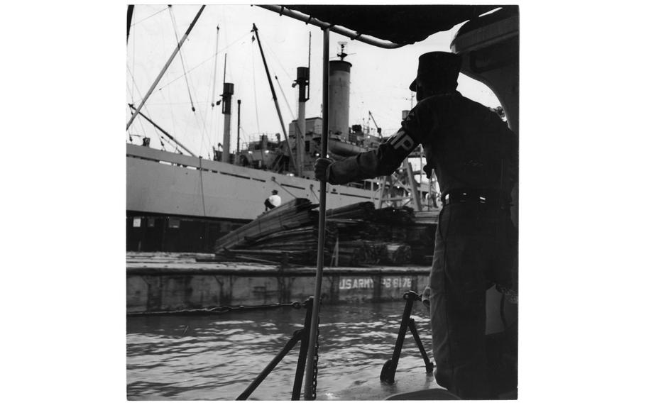 A freighter unloading in Incheon harbor is checked by the 8224th Military Police Detachment patrol in September 1958. Everything that floats, from freighters to sampans, comes under the patrol’s watchful eye.