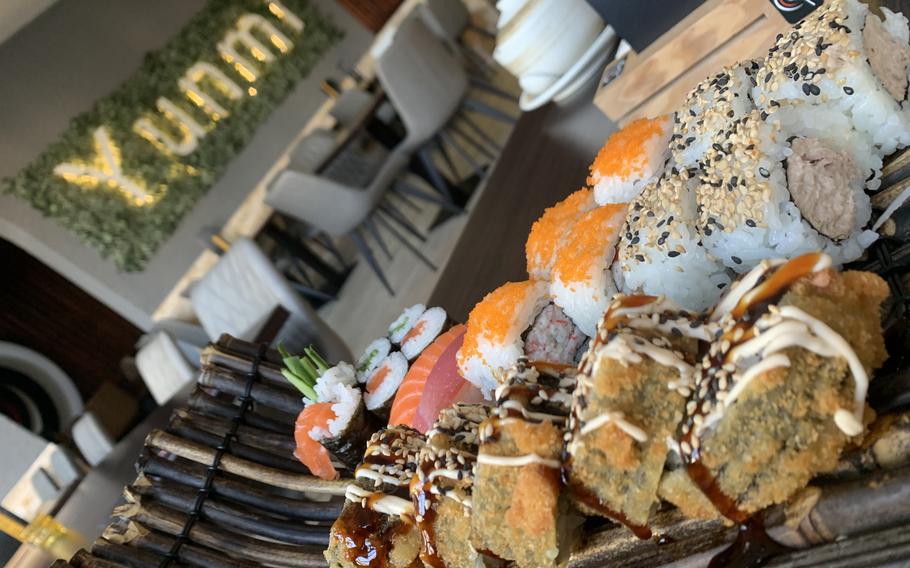 This sampling of maki, nigiri and inside-out sushi rolls includes Canadian rolls filled with a mixture of imitation crab and cream cheese and topped with orange salmon roe, center back, as well as a fried salmon roll, center front.