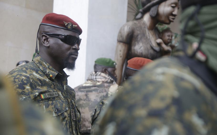 Guinea's Junta President Col. Mamady Doumbouya, center, is heavily guarded by soldiers after a meeting with ECOWAS delegation in Conakry, Guinea Friday, Sept. 10, 2021.