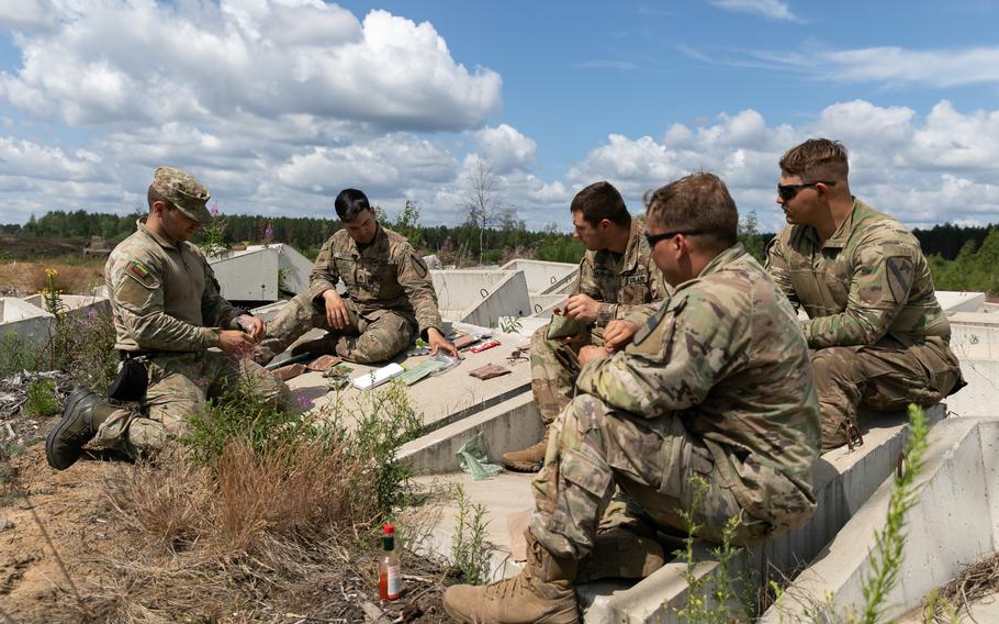U.S. soldiers exchange military meals ready-to-eat with a Lithuanian soldier during a break in training at Pabrade Training Area, Lithuania, July 13, 2023. The Senate on July 19 passed an amendment to next year's defense authorization bill that would prohibit any president from unilaterally pulling the country out of the NATO alliance.