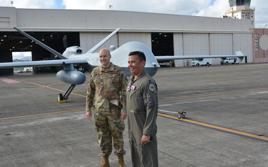 Col. Ryan Keeney, left, commander of the 49th Wing, and Lt. Col. Jaime Olivares, commander of the 9th Attack Squadron, both based at Holloman Air Force Base, N.M., pose near a Reaper drone at Marine Corps Base Hawaii, Monday, Sept. 27, 2021.