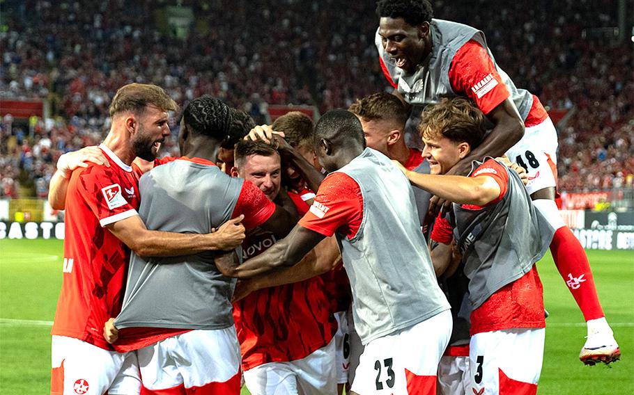 Soccer players celebrate a goal.