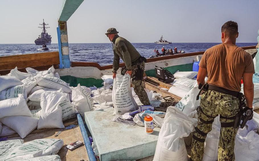 Crew members of USS The Sullivans and patrol coastal ship USS Hurricane, seen in the background, inventory a large quantity of urea fertilizer and ammonium perchlorate discovered on board a fishing vessel intercepted by U.S. naval forces while transiting international waters in the Gulf of Oman, Nov. 9