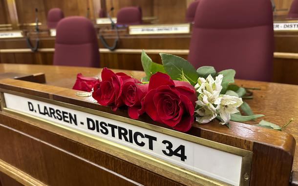 Roses rest on the Senate desk of late North Dakota Republican state Sen. Doug Larsen, at the state Capitol Monday, Oct. 2, 2023, in Bismarck, N.D. Larsen, his wife Amy, and their two young children died Sunday in a plane crash near Moab, Utah. Larsen was first elected to the state Senate in 2020.