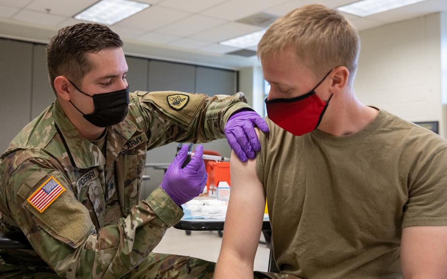 Army Spc. Tristan Spoerri with the Utah National Guard Medical Detachment administers the first dose of the coronavirus vaccine to a soldier at Camp Williams, Utah, in September 2021. The Defense Department ordered mandatory vaccinations to protect troops and ensure force readiness. 