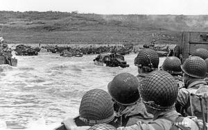 Troops watch activity ashore on Omaha Beach as their LCVP landing craft approaches the shore on D-Day, 6 June 1944. 