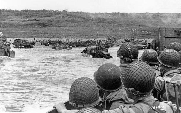 Troops watch activity ashore on Omaha Beach as their LCVP landing craft approaches the shore on D-Day, 6 June 1944. 