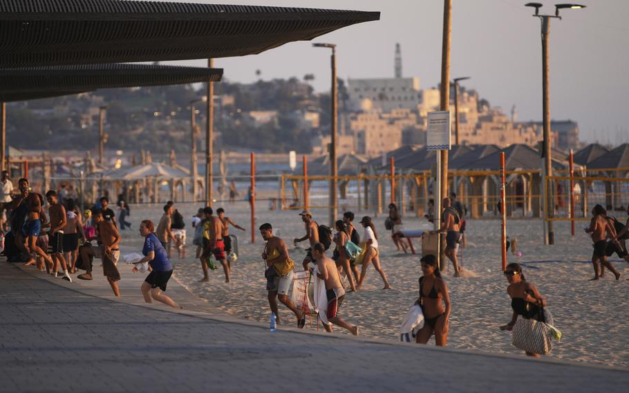 Beachgoers leave the beach.