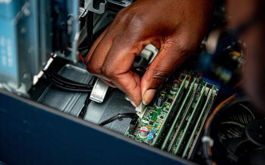 An information systems technician repairs a computer aboard Nimitz-class aircraft carrier USS Carl Vinson, June 28, 2022. A Rand Corp. review of Defense Department personnel records showed white males working similar high-tech jobs making more money on average than women and minorities.