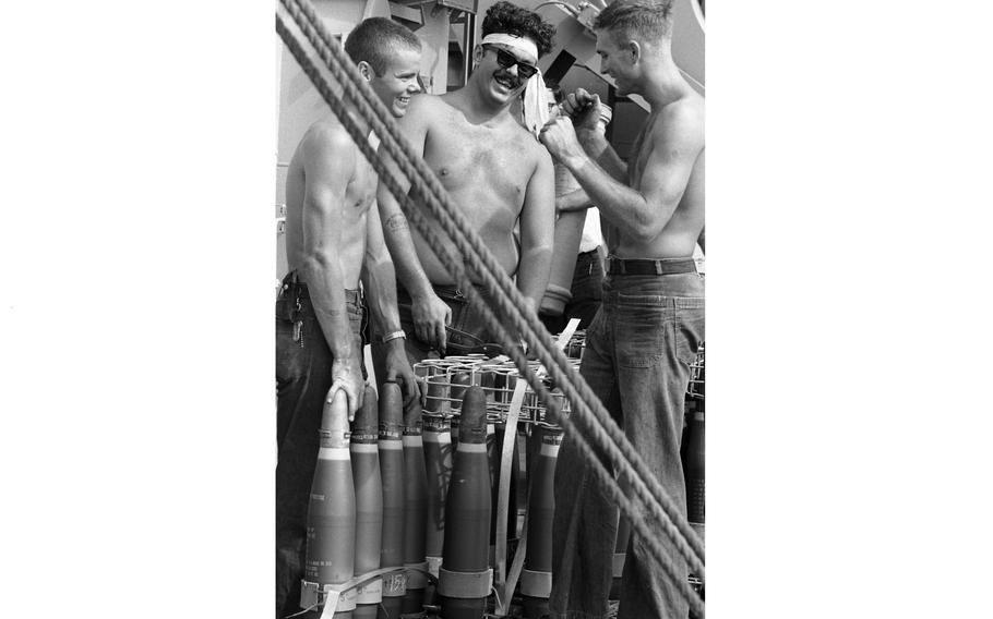 Three sailors laugh together on the USS Buchanan