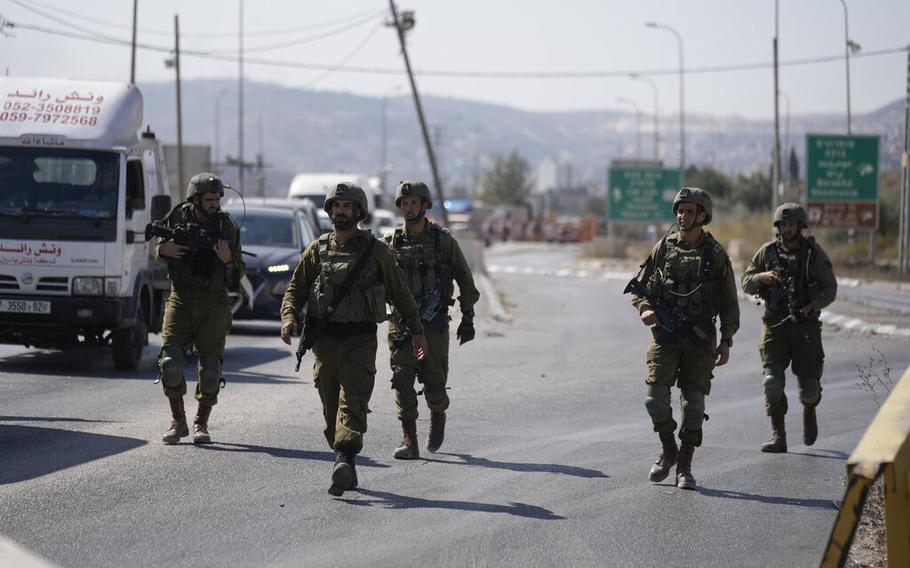 Israeli soldiers forces block the Hawara checkpoint, the main entrance to the West Bank city of Nablus, Wednesday, Oct. 12, 2022.