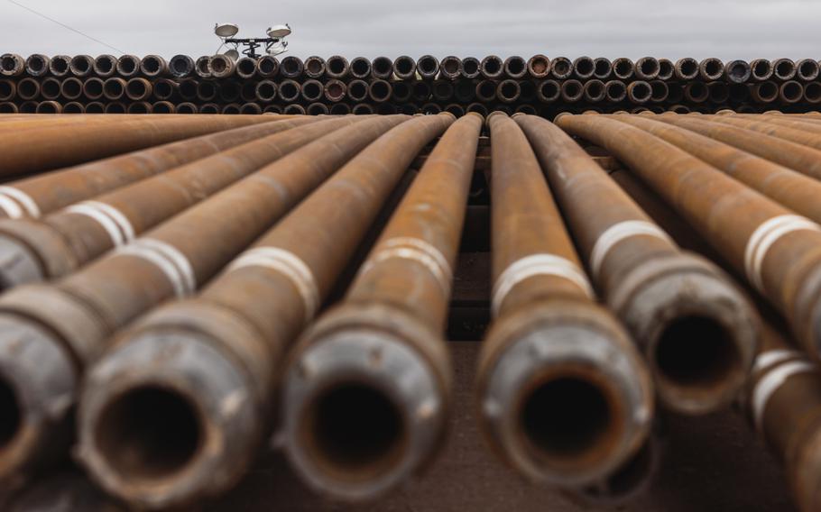 Stacks of steel pipes used for drilling oil wells at a drilling site on the land that the University of Texas System overseas in Andrews, Texas, in June 2022. 