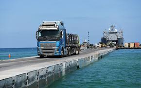 A DoD-contracted driver transports humanitarian aid from the U.S. Army vessel LSV-5, across the Trident Pier, and onto the beach in Gaza, June 20, 2024. The temporary pier, part of the Joint Logistics Over-the-Shore capability, enables the maritime delivery of international humanitarian aid to the citizens of Gaza. (U.S. Navy photo by Mass Communication Specialist 1st Class Jordan KirkJohnson)