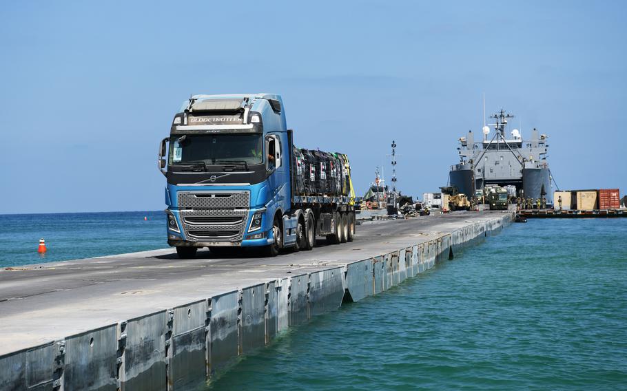 Truck drives across floating pier.