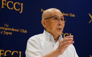 An older man gestures with one hand as he speaks.