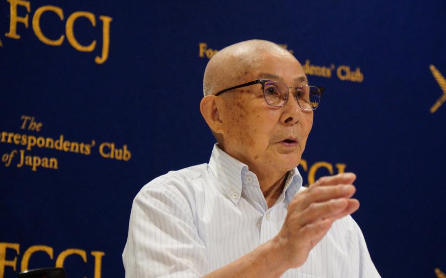 An older man gestures with one hand as he speaks.