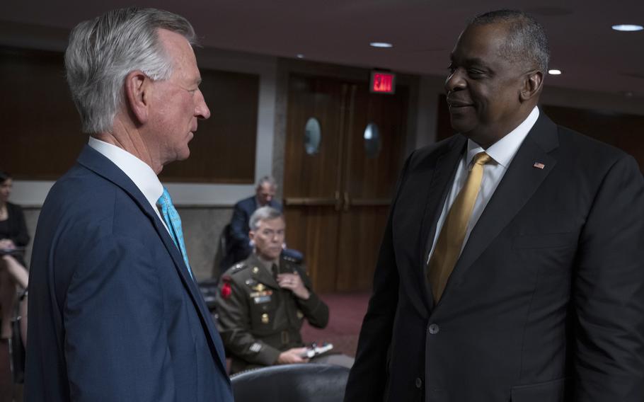 Defense Secretary Lloyd Austin speaks in June 2021 with Sen. Tommy Tuberville, R-Ala., prior to a Senate Armed Services Committee hearing on the Defense Department budget. 